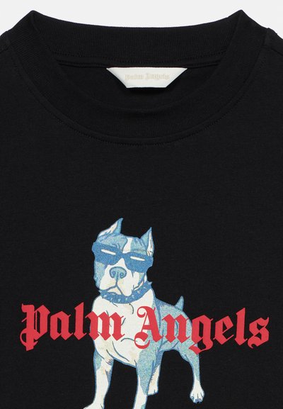 Μαύρο πουκάμισο με γραφικό μια μπλε και λευκή σκύλου που φοράει γυαλιά ηλίου και περιλαίμιο, με το κείμενο «Palm Angels» σε κόκκινα γοτθικά γράμματα από κάτω.