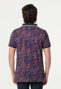 Korte mouwen polo shirt in donkerpaars met een bladerenpatroon in oranje en mauve. Bevat een kraag met contrasterende bies. Textuurstof.
