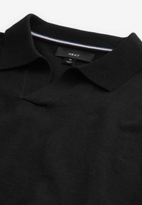 Sort v-hals sweater lavet af strikket stof, med en flad krave der har en blå, hvid og rød stribe som accent. Størrelsesmærkat synlig.