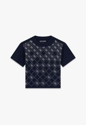 Navy blue short-sleeve crop top with white diamond grid pattern and repeated GUESS logo design across the front.