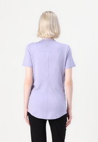 Světlofialové sportovní tričko s krátkými rukávy, zaobleným lemem a malým logem Nike na zadním výstřihu, vyrobené z hladké látky.