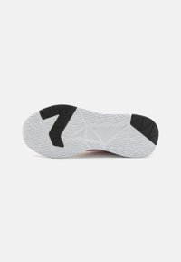 Semelle de chaussure de sport noir et blanc avec un motif de grip texturé. Présente une section noire proéminente et des designs géométriques sur une base blanche.