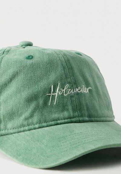 Πράσινο βαμβακερό καπέλο μπέιζμπολ με ελαφρώς κυρτή γείσο και το «Holzweiler» κεντημένο με λευκά γράμματα στο μπροστινό πάνελ.