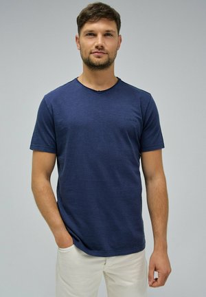 Camiseta de manga corta color azul marino con escote en V y una textura sutil. Corte ajustado con un pequeño detalle de logotipo en el área del pecho izquierdo.