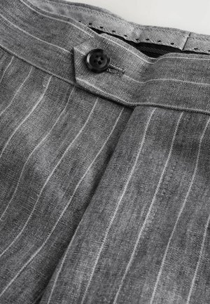 Gray striped fabric featuring a black button, detailed waistband, and a textured interior lining. Textiles appear lightweight and breathable.