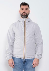 Giacca a vento grigio chiaro con cappuccio e zip frontale, caratterizzata da dettagli della zip multicolore. Polsini e orlo elastici, tessuto morbido, vestibilità casual.