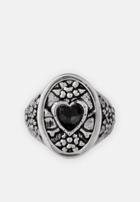 Sterling zilveren ring met een ovale vorm en bloemdetails; een hartvormige zwarte edelsteen in het midden. Geïmiteerde band.