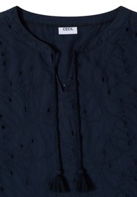 Blouse bleu foncé avec broderie florale, encolure ronde et liens à nouer à l'avant avec pompons, étiquette de la marque Cecil à l'intérieur du col.