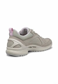 Scarpa da ginnastica grigio chiaro realizzata in materiali in rete e suede, con collo imbottito, suola testurizzata e un accento rosa sul tallone.
