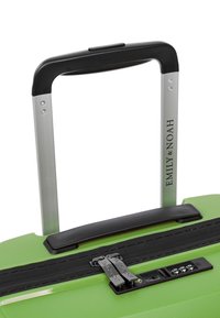 Zelený tvrdý kufr s texturovaným povrchem, černým zipem a kombinovaným zámkem, stříbrná rukojeť a značka "EMILY & NOAH" na rukojeti.