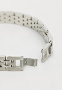 Metallarmband aus Silber mit ineinandergreifenden Gliedern, glänzender Oberfläche, rechteckiger Form und einem Kettenverschluss.