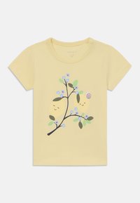 Gul bomullströja med korta ärmar som har en tryckt design av leende citroner, en snigel och blommor på en gren.
