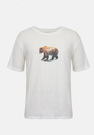 T-shirt blanc à manches courtes avec un dessin d'ours en marche rempli d'un paysage de forêt et de coucher de soleil sur la poitrine.