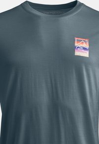 Blaues T-Shirt mit kurzen Ärmeln aus einem glatten Stoff, das ein mehrfarbiges Grafiklogo auf der Brust mit Berghügel- und Wellenmotiven zeigt.