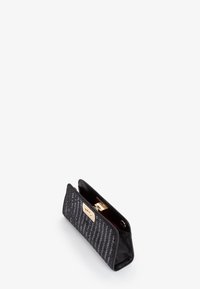 Borsa a pochette nera con tessuto texturizzato e hardware dorato. Chiusura a patta con un dettaglio metallico. Interno foderato in tessuto rosso.