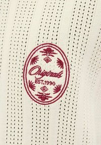 Baltas mezgimo audinys su reljefinėmis juostomis ir mažomis skylutėmis. Bordo siuvinėtas ovalus logotipas, tekstas "Original EST.1990" ir gėlių akcentai.