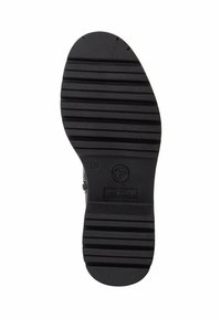 Semelle de chaussures en caoutchouc noir avec une texture striée, un motif circulaire et des détails de marquage en relief, conçue pour l'adhérence et la durabilité.