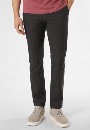 Schwarze, strukturierte Slim-Fit-Hosen mit glatter Oberfläche, kombiniert mit hellgrauen Sneakers mit kontrastierender Sohle und Schnürdesign.