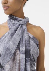 Grå och svart mönstrad scarf med en knuten design. Tillverkad av mjukt, texturerat tyg, med draperade tyger som betonar dess flöde.