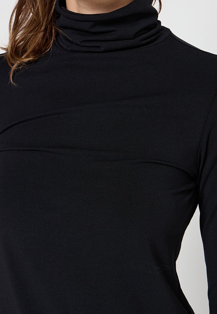 Schwarzes Rollkragenoberteil mit taillierter Passform, aus glattem Stoff, mit dezenten, geschwungenen Nähten und hohem Kragen.