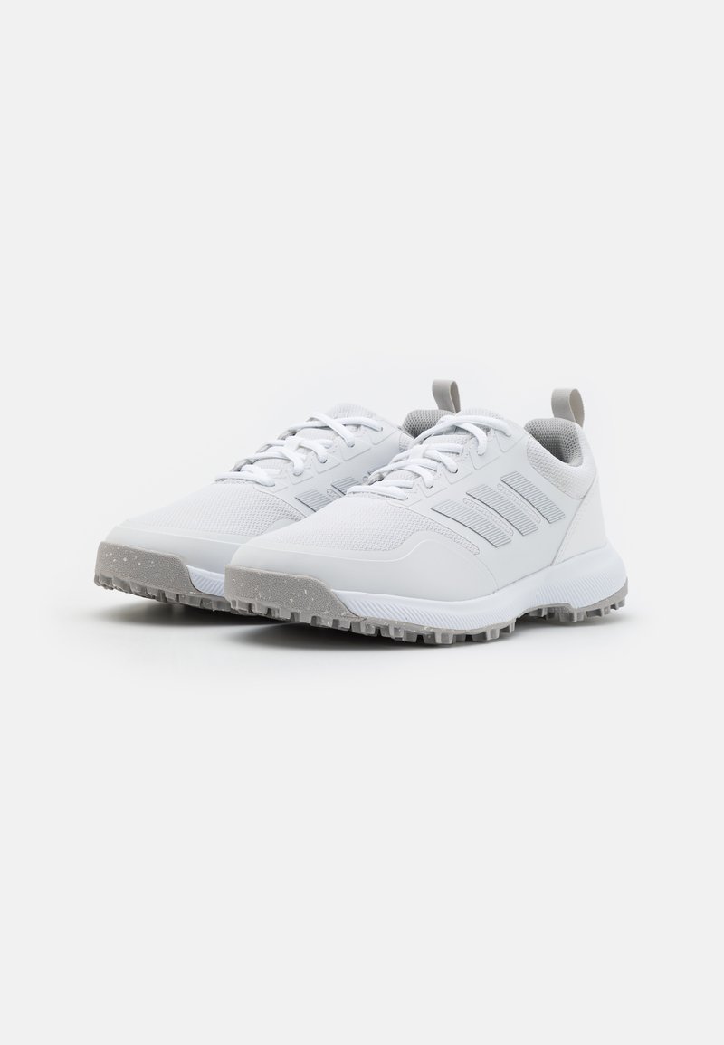 Weiße Sportschuhe mit einem strukturierten Mesh-Obermaterial, drei grauen Streifen an der Seite und einer grauen Gummi-Außensohle mit Profilmustern.