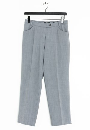 Pantalon habillé gris clair avec poches avant, passants pour ceinture et fermeture par bouton, suspendu sur un cintre noir sur fond blanc.