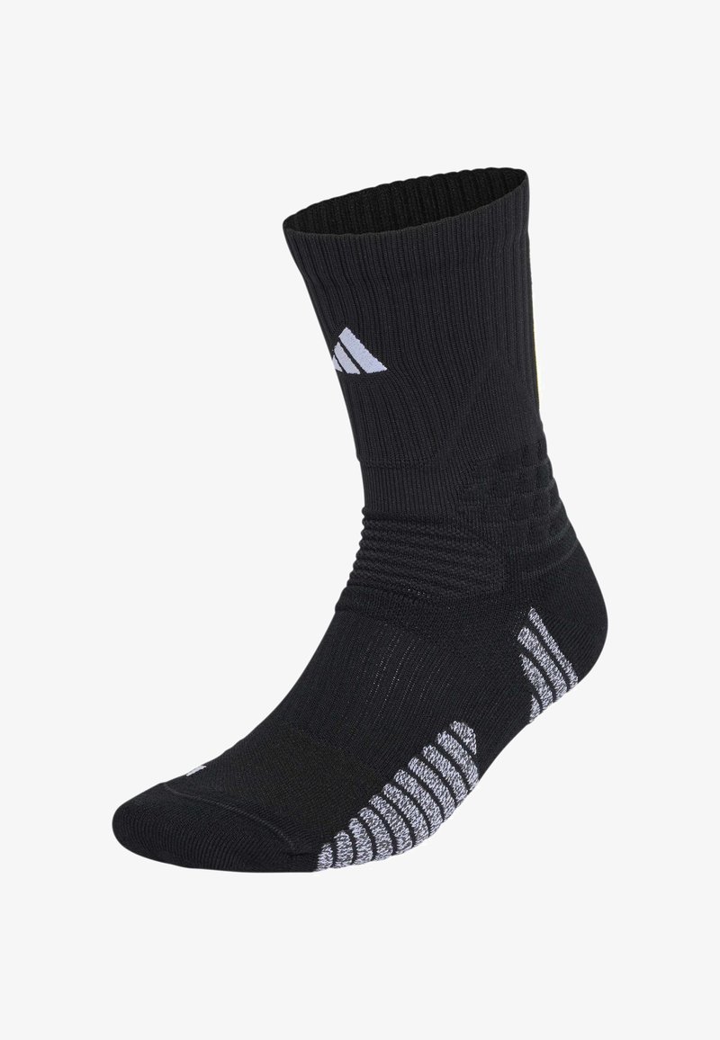 Sort atletisk sok midt på læggen med hvide stribede grebsmønstre på sålen og logo nær anklen, ribbet struktur for støtte.