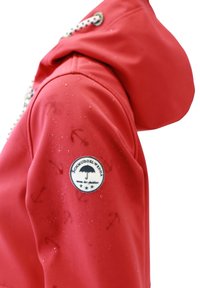Giacca impermeabile rossa con cappuccio, caratterizzata da una toppa con logo, motivo di ancore e chiusura con coulisse. Texture liscia con gocce d'acqua.