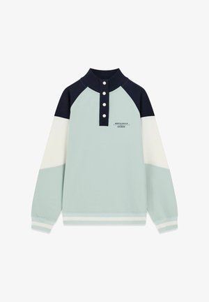 Lichtblauwe, witte en marineblauwe trui met lange mouwen, hooggesloten knoopkraag en "North Sails Guess"-logo op de borst.