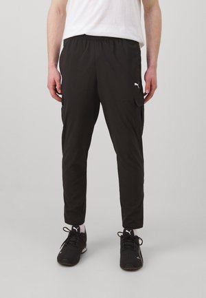 Czarne spodnie cargo wykonane z lekkiego materiału, z elastycznym paskiem w talii, bocznymi kieszeniami oraz białym logo na udzie.