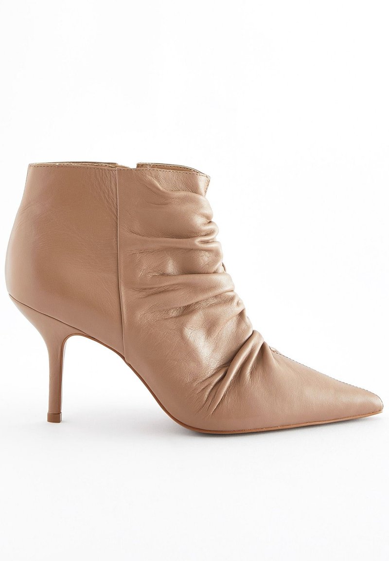 Beige leather ankle boot with a pointed toe, ruched design, and a stiletto heel, featuring a smooth texture and minimalist construction.
