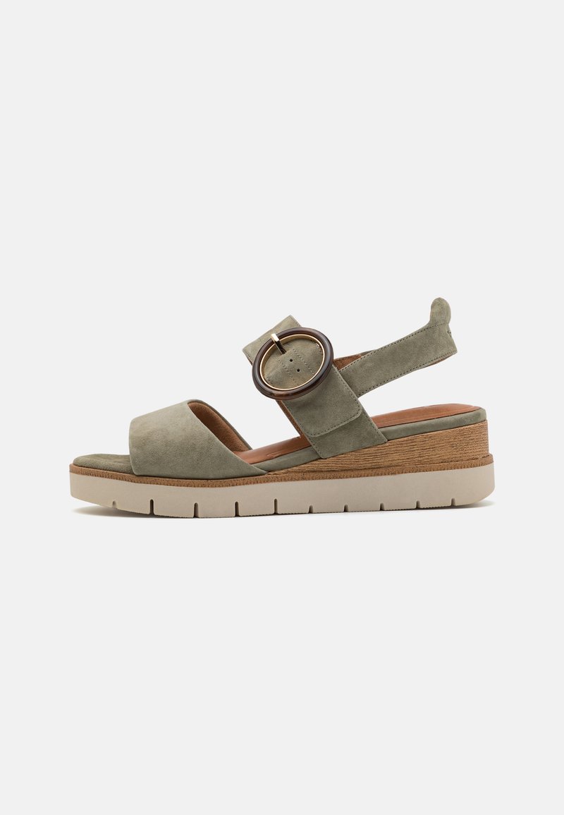 Sandal i olivengrønn mocka med en bred tårem, justerbar hælrem, sirkulært metallhardware-tilbehør og en kraftig, strukturert såle.
