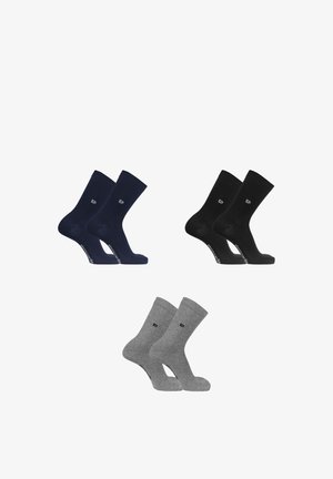 Trois paires de chaussettes montantes en bleu marine, noir et gris, chaque paire présentant un petit logo près de la cheville et un texte sur la semelle du pied.