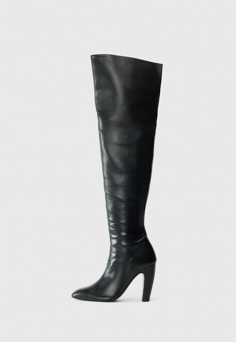 Stivali neri in pelle al ginocchio con un design aderente, punta affilata e tacco alto. Texture liscia e stile minimalista.
