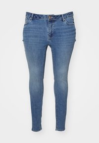 Skinny blue jeans made of denim with a faded finish. Features a five-pocket design and a button closure at the waist.