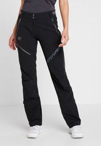 Sorte udendørs bukser med en slim fit, der har grå lynlåse, et logo på låret og justerbare taljebånd for komfort og pasform.