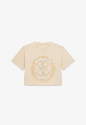 Beżowy krótki t-shirt z krótkim rękawem, okrągłym dekoltem i okrągłym ozdobnym emblematem z detalem frędzli na środku.