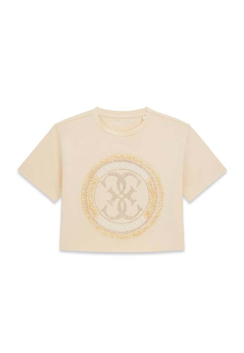 T-shirt beige court à manches courtes avec encolure ronde et emblème décoratif circulaire avec détails en franges au centre.