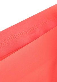 Tessuto corallo rosa con una superficie liscia e una finitura opaca e morbida. Presenta un marchio in rilievo lungo il bordo.