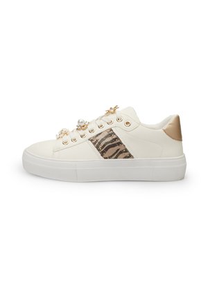 Sneaker bianca con una fascia metallica texturizzata che presenta un motivo a zebra, gemme decorative e dettagli in finitura dorata. Suola piatta.