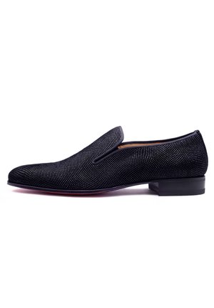 Chaussure noire à enfiler avec un tissu texturé, présentant un bout arrondi lisse et un talon plat fin ; inclut des détails de couture subtils et aucun élément en métal.