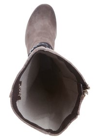 Bottine en suède gris avec un intérieur doux, fermeture éclair et une sangle décorative noire ornée de clous sur le bord supérieur.