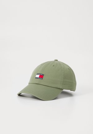 Lichtgroene baseballpet met gebogen klep en Tommy Jeans logo-patch aan de voorkant tegen een witte achtergrond.