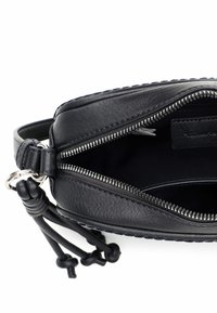 Czarna skórzana torebka z zamkiem błyskawicznym. Posiada pleciony detal wzdłuż krawędzi oraz skórzane, wiązane akcenty. Wnętrze jest gładkie.