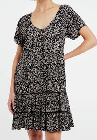 Musta mekko lyhyillä hihoilla, pyöreällä kaula-aukolla, pinkki-valkoisella kukkakuviolla, nappitiedoilla ja kerroksellisella röyhelöhelman. Pehmeä, kevyt kangas.