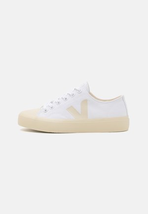Scarpa da ginnastica bassa in tela bianca con suola in gomma beige, puntale beige, lacci bianchi e logo "V" beige sul lato.