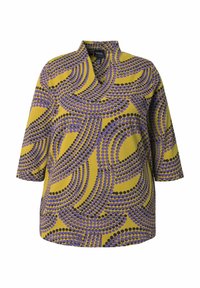 Driekwart mouwbloes in gele stof met een gedurfde cirkelvormige print in paars en zwart, met een mandarin kraag en rechte zoom.