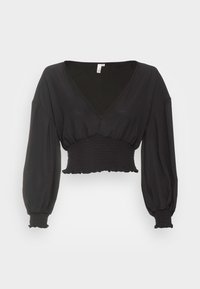 Top nero cropped con scollatura a V profonda, maniche lunghe a palloncino e vita elastica arricciata. Tessuto liscio con una leggera lucentezza.