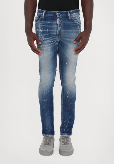 Blauwe denim jeans met een aansluitend ontwerp, featuring een vervaagde was, versleten details en spetterpatronen. Afgewerkt met een klassieke rits.