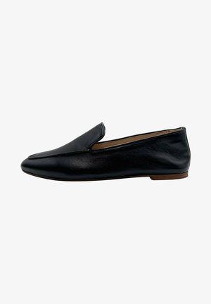 Mocasines de cuero negro con una textura suave, punta afilada y un tacón bajo y plano, que cuentan con detalles de costura minimalistas y un diseño sin cordones.